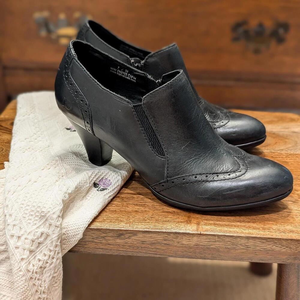 Chakri black leather wingtip side zip ankle booties.
